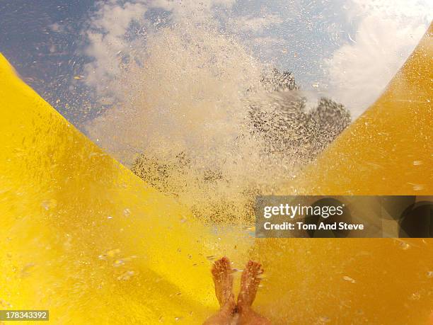 riding a waterpark waterslide - water slide stock pictures, royalty-free photos & images