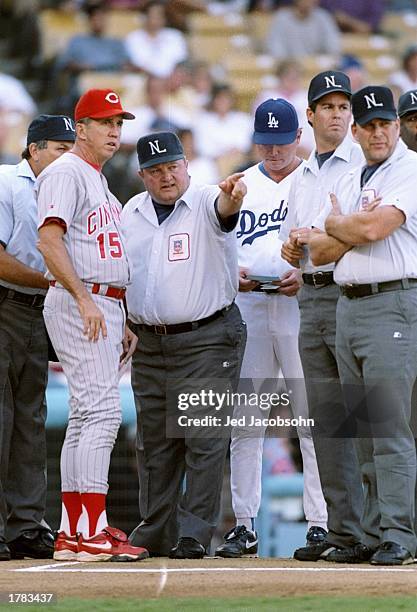 Manager Davey Johnson of the Cincinnati Reds looks on as umpire Bruce Froemming explains the ground rules before the start of Game 1 of the National...