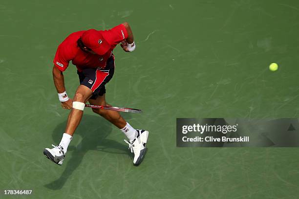 Carlos Berlocq of Argentina returns a shot through his legs during his men's singles second round match against Roger Federer of Switzerland on Day...