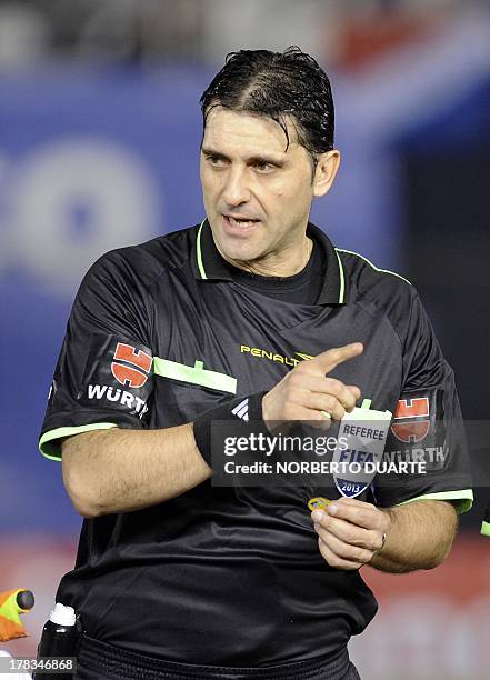 Uruguayan referee Dario Ubriaco speaks with players during a Copa Sudamericana football match between Praguay's Nacional and Ecuador's Liga de Loja,...