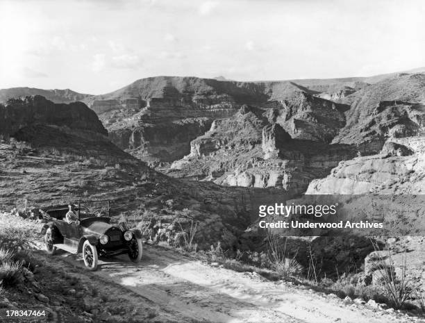 Lone car out in Fish Creek canyon in the Superstition Mountains with the Painted Cliffs in the background, Fish Creek Canyon, Arizona, April, 1916.