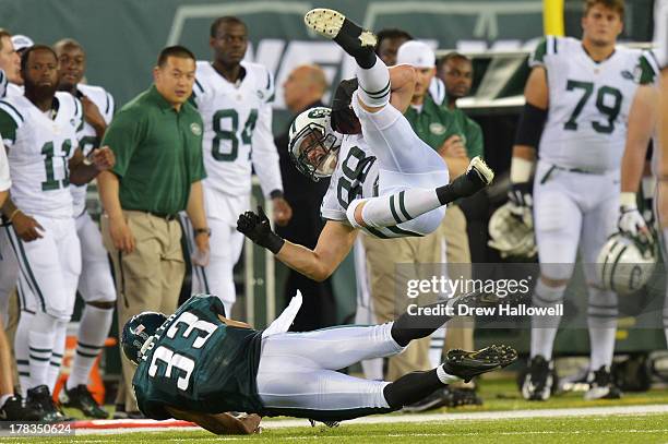 Konrad Reuland of the New York Jets gets upended by Emmanuel Acho of the Philadelphia Eagles at MetLife Stadium on August 29, 2013 in East...