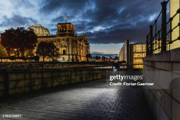 Cyclist is pictured in front of the German Bundestag during blue hour on November 15, 2023 in Berlin, Germany.