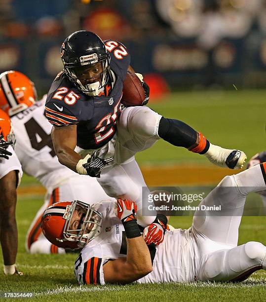 Armando Allen of the Chicago Bears tries to break away from Tank Carder of the Cleveland Browns at Soldier Field on August 29, 2013 in Chicago,...