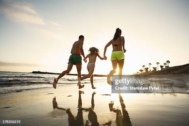 family running on beach at sunset - canary island beach stock pictures, royalty-free photos & images