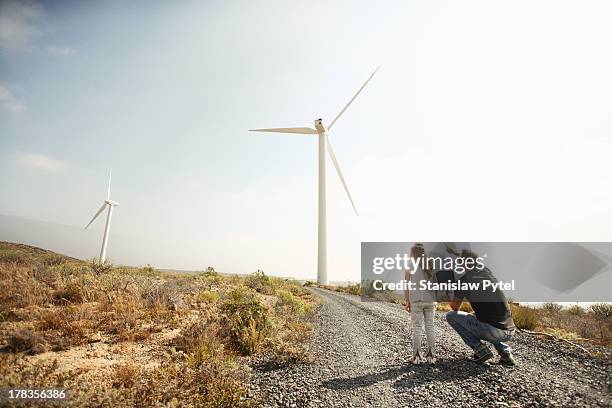 father showing daughter windmills - windenergie stock-fotos und bilder