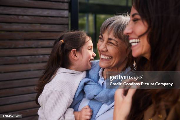 niña riendo de pie afuera con su abuela y mamá - madre e hija fotografías e imágenes de stock