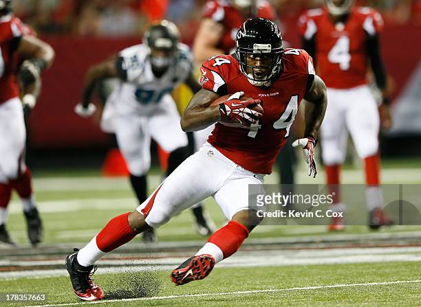 Jason Snelling of the Atlanta Falcons slips as he rushes a reception upfield against the Jacksonville Jaguars at Georgia Dome on August 29, 2013 in...