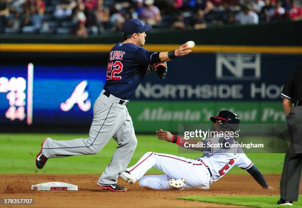 Jason Kipnis of the Cleveland Indians turns a double play against B. J. Upton of the Atlanta Braves at Turner Field on August 29, 2013 in Atlanta,...