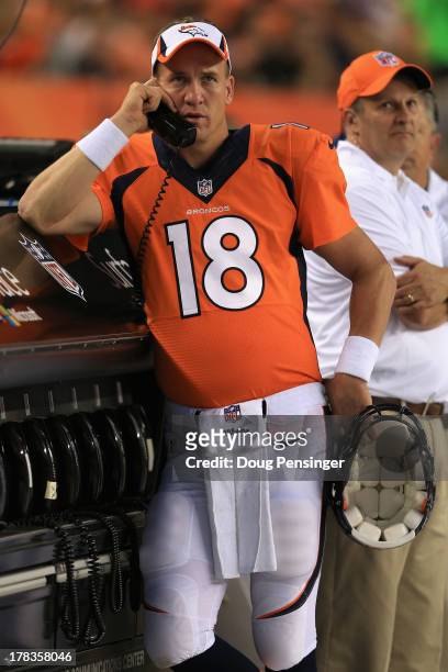 Quarterback Peyton Manning of the Denver Broncos talks on the phone on the sidelines as they Broncos host the Arizona Cardinals during preseason...