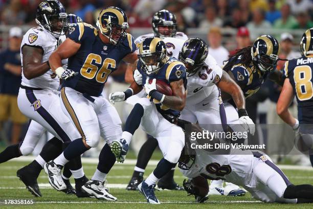 Isaiah Pead of the St. Louis Rams slips a tackle by Alex Copeland of the Baltimore Ravens during a pre-season game at the Edward Jones Dome on August...