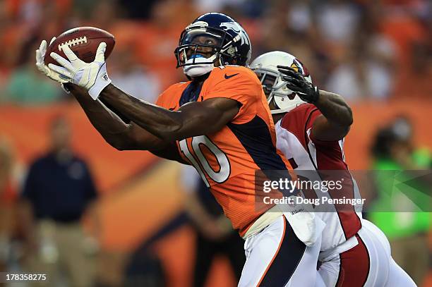 Wide receiver Gerell Robinson of the Denver Broncos makes a 45 yard pass reception against the defense of cornerback Javier Arenas of the Arizona...