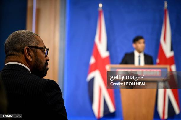 Britain's Home Secretary James Cleverly reacts as listens to Britain's Prime Minister Rishi Sunak during a press conference following the Supreme...