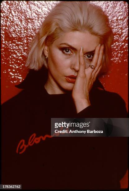 Portrait of American singer Debbie Harry, of the band Blondie, as she poses against a vinyl backdrop, New York, New York, 1970s.