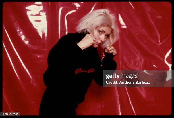 Portrait of American singer Debbie Harry, of the band Blondie, as she poses against a vinyl backdrop, New York, New York, 1970s.