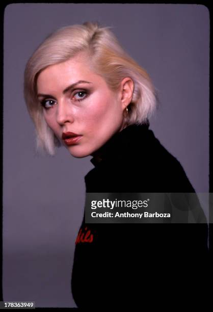 Portrait of American singer Debbie Harry, of the band Blondie, as she poses against a grey backdrop, New York, New York, 1970s.