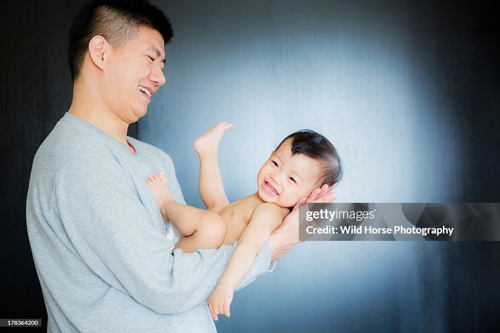 Happy daughter  lying on father's arms