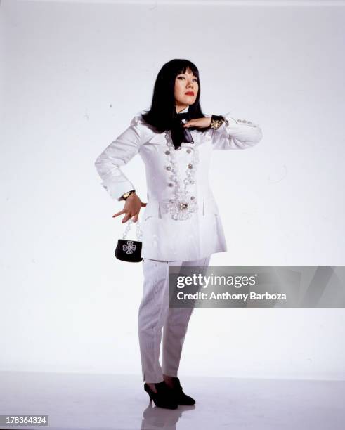 Portrait of American fashion designer Anna Sui as she poses, dressed in a white suit, against a white background in a studio, New York, New York,...