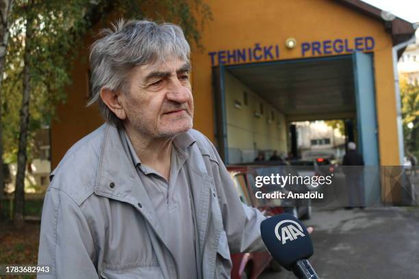 Kosovo Serb Dragan Kostic, waiting for the license plate registration process in front of the vehicle inspection station, speaks to press as people...