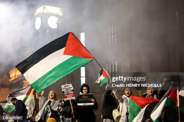 Protesters hold placards and flags as they chant slogans during a rally in support of Palestinians, outside of the Houses of Parliament in central...