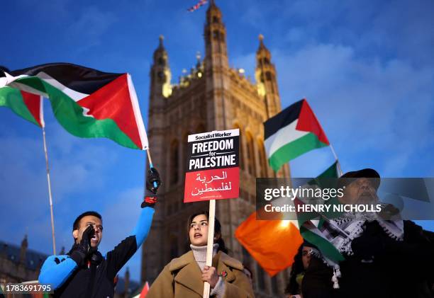 Protesters hold placards and flags as they chant slogans during a rally in support of Palestinians, outside of the Houses of Parliament in central...