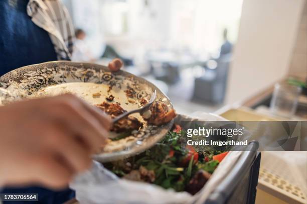 teenage boy throwing out lunch leftovers to an organic compost container. - leftover stockfoto's en -beelden