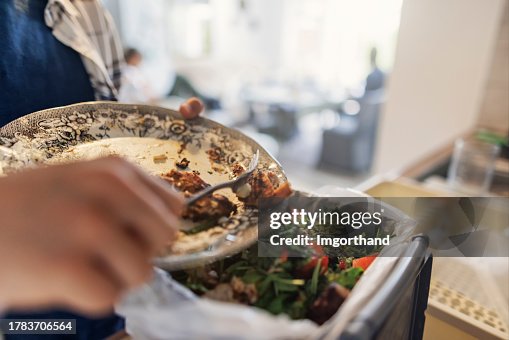 Teenage boy throwing out lunch leftovers to an organic compost container. Teenage boy throwing out lunch leftovers to an organic compost container.