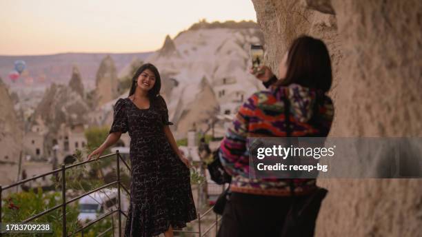 two multi-racial female friends taking photos in cappadocia - göreme national park stock pictures, royalty-free photos & images