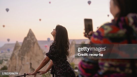 Two multi-racial female friends taking photos in Cappadocia