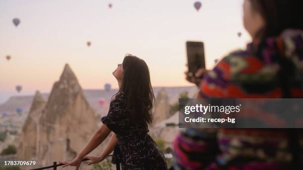 two multi-racial female friends taking photos in cappadocia - göreme national park stock pictures, royalty-free photos & images