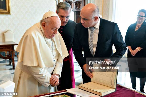 Pope Francis exchanges gifts with the president of the Swiss Confederation Alain Berset during an audience at the Apostolic Palace on November 09,...