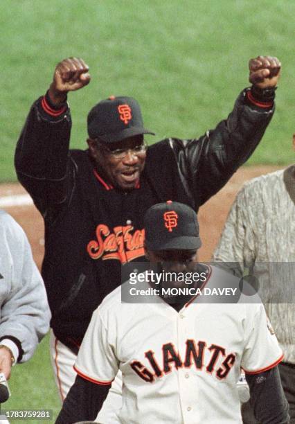 San Francisco Giants manager Dusty Baker pumps his arms while Giants Barry Bonds walks towards the dugout after defeating the Arizona Diamondbacks to...