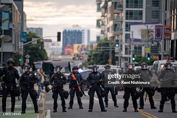 Police officers form a line as protestors gather at the intersection of Fifth and Mission to block delegates, staff and security personnel from...