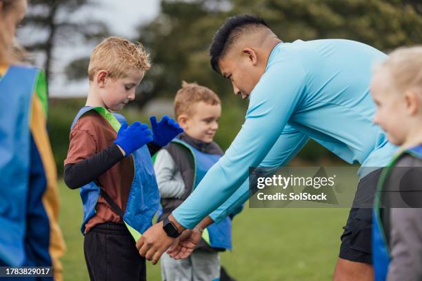 putting on sports bibs - male teacher stock pictures, royalty-free photos & images