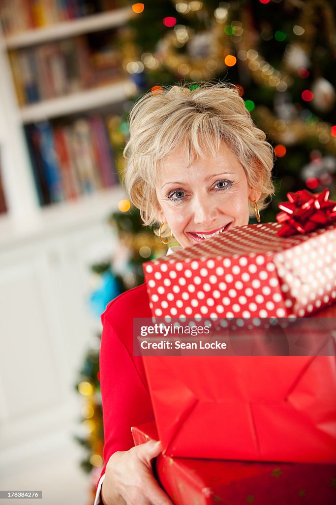 Woman Behind Stack of Christmas Gifts