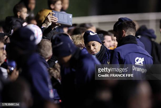 France's forward Kylian Mbappe poses with supporters ahead of a training session in Clairefontaine-en-Yvelines on November 15, 2023 as part of the...