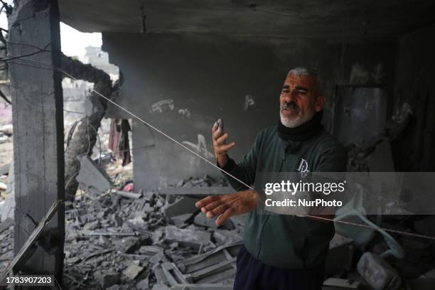 Palestinian man stand in his home destroyed during the Israeli bombardment of Gaza, in Deir el-Balah, in the central Gaza Strip on November 15 amid...