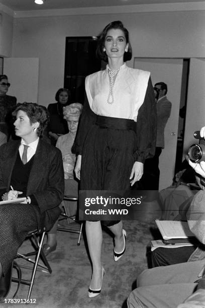 Model Margaret Donohoe presents an ensemble from the spring 1985 ready to wear collection inside of designer Pauline Trigère's New York City showroom.