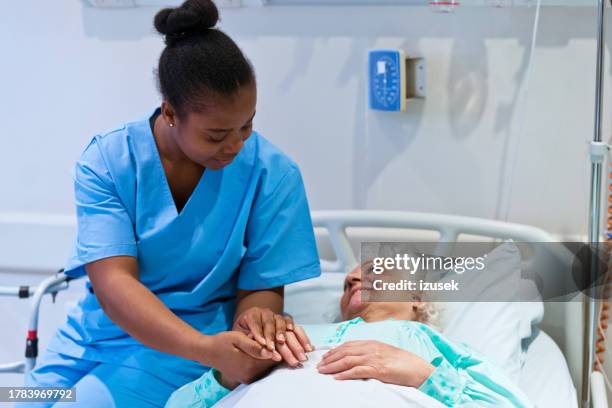 nurse consoling senior patient in hospital - medicare form stock pictures, royalty-free photos & images