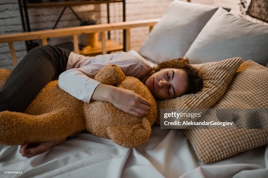Hembra Disfrutando Del Calor Del Oso De Peluche Mientras Se Duerme
