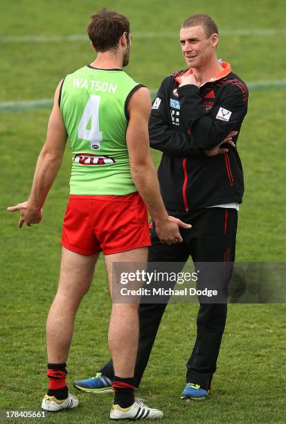 Jobe Watson speaks to interim senior coach Simon Goodwin during an Essendon Bombers training session at Windy Hill on August 30, 2013 in Melbourne,...