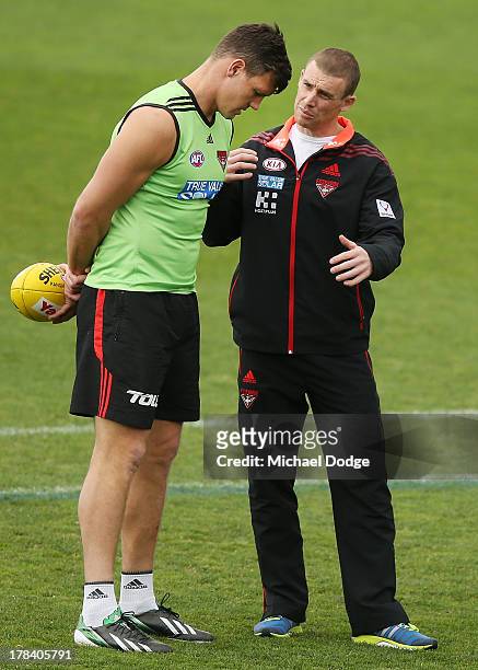 Bombers interim senior coach Simon Goodwin talks to David Hille during an Essendon Bombers training session at Windy Hill on August 30, 2013 in...