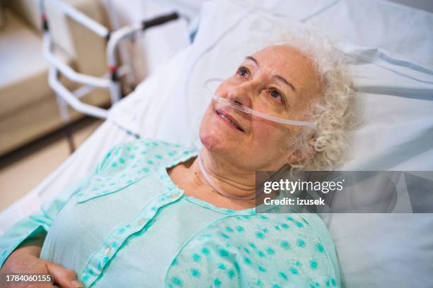 paciente mayor con tubo de oxígeno acostado en el hospital - tubo de oxígeno fotografías e imágenes de stock