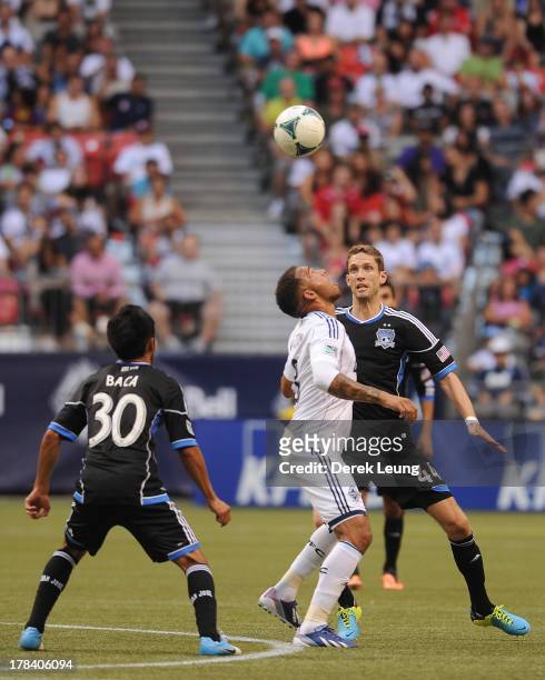 Matt Watson of the Vancouver Whitecaps heads the ball in front of Clarence Goodson of the San Jose Earthquakes during an MLS match at B.C. Place on...