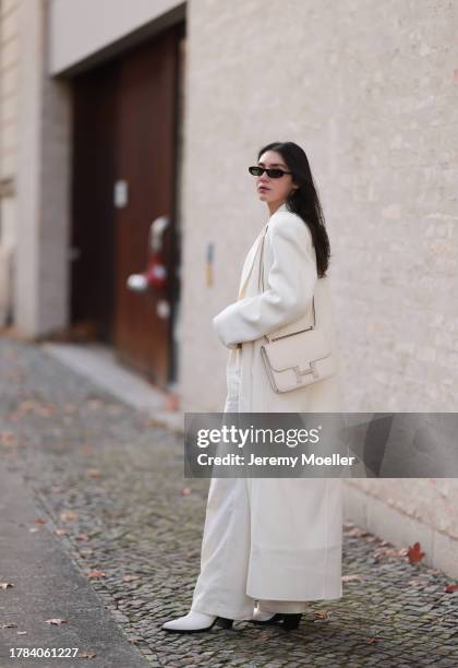 Milena Karl seen wearing Saint Laurent black sunglasses, Orse und Iris white transparent top, Massimo Dutti white suit pants, The Frankie Shop cream...