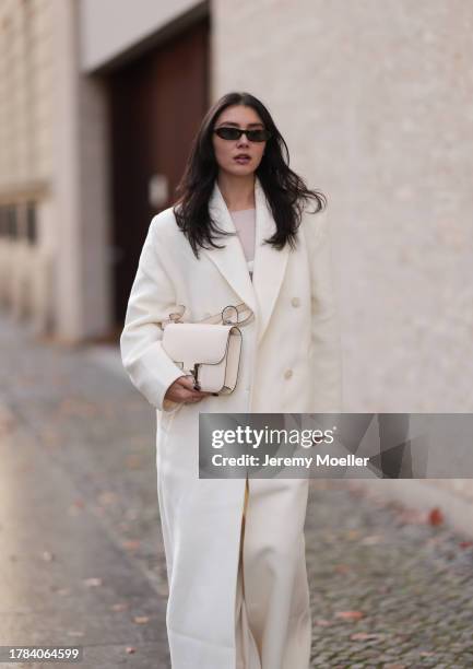 Milena Karl seen wearing Saint Laurent black sunglasses, Orse und Iris white transparent top, Massimo Dutti white suit pants, The Frankie Shop cream...