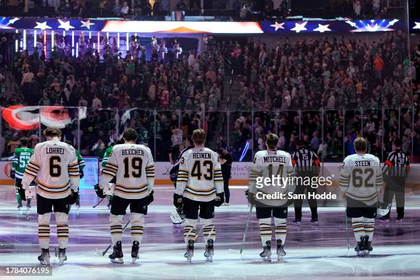 Mason Lohrei, Johnny Beecher, Danton Heinen, Ian Mitchell, and Oskar Steen of the Boston Bruins stand during the playing of the U.S. National anthem...