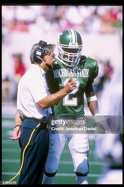 Coach Nick Saban speaks with John Muskett of the Michigan State Spartans during a game against the Nebraska Cornhuskers at Spartan Stadium in East...