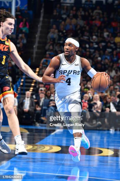 Devonte Graham of the San Antonio Spurs dribbles the ball during the game against the Oklahoma City Thunder on November 14, 2023 at Paycom Arena in...