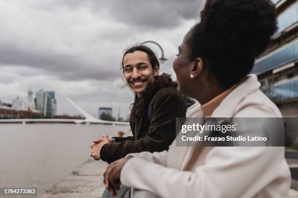 young friends talking in puerto madero, buenos aires - puerto stock pictures, royalty-free photos & images